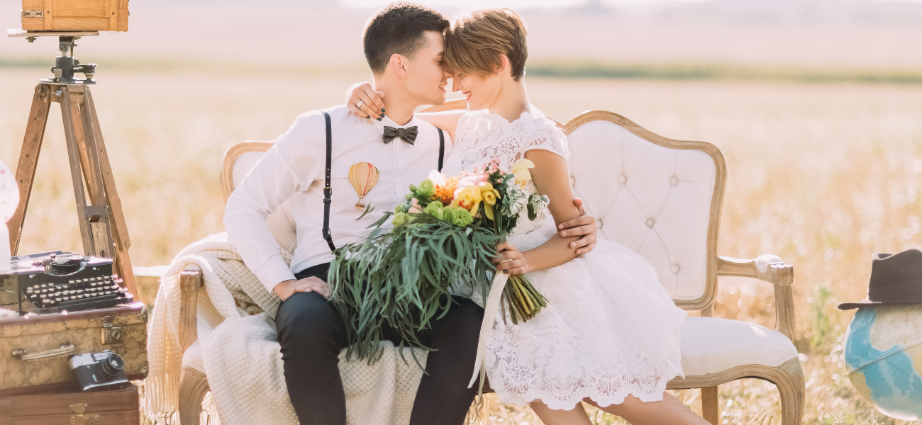 Bild Hochzeitspaar sitzt auf Sofa mit stilvoll gestalteten Requisiten.